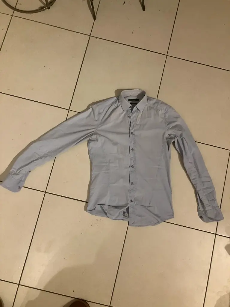Before: wrinkled shirt on tiled floor, unprofessional flat lay